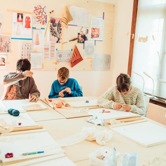 Kinderen zijn aan het knutselen in de Conciërgerie van het museum